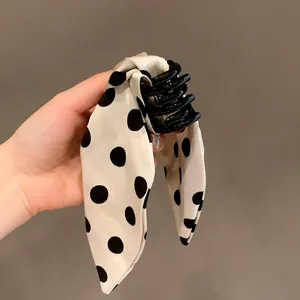 Elegant cream bow hair claw clip with black polka dots for women's stylish buns