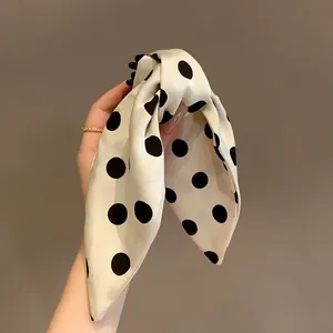 Close-up of elegant polka dot bow hair claw clip with silk-like texture