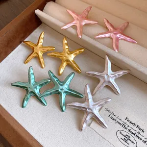 Macro view of textured starfish earrings in assorted metallic colors inside a jewelry box