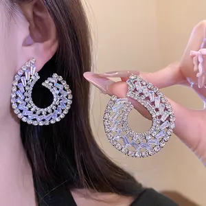 Gros plan détaillé de boucles d'oreilles pendantes géométriques en zircon