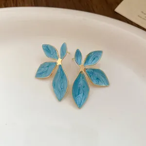 Close-up of blue marbled enamel leaf-shaped stud earrings with exquisite gold plating finish
