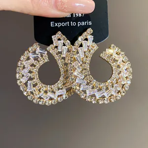 Gros plan sur d'élégantes boucles d'oreilles en or avec zircons baguette et ronds.