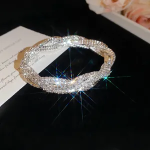 Nahaufnahme eines funkelnden, mit Strass besetzten, geflochtenen Armbands auf Samt