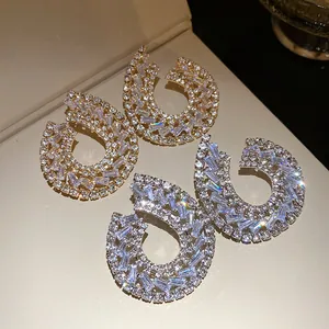 Vue détaillée de boucles d'oreilles clous en aiguille d'argent serties de zircons