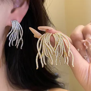 Detailed shot of sparkling zircon tassel earrings in gold and silver finishes