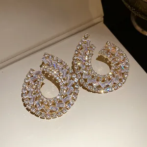 Détail macro de boucles d'oreilles gouttes géométriques avec zircons étincelants