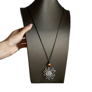 Silver-tone hollow flower pendant long necklace with black cord and orange bead