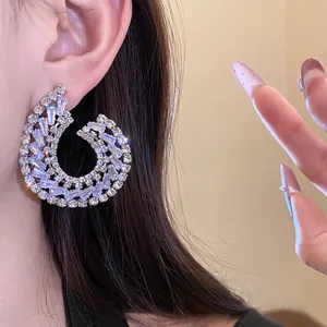 Gros plan d'une boucle d'oreille de luxe en zircone en forme de C, vue détaillée exquise.