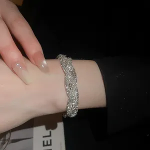 Nahaufnahme eines funkelnden Strass-Armbands mit Flechtmuster am Handgelenk