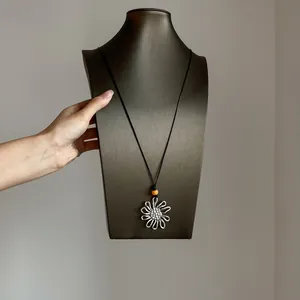 Ethnic retro flower necklace on black cord with vibrant orange bead accent for stylish layering