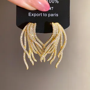 Detailed macro view of 18k gold plated silver needle earrings with pavé zircons