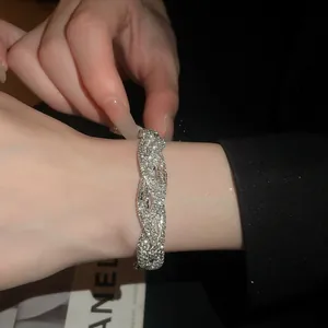 Makro-Detail eines luxuriösen Vintage-Armbands mit gewebten Strasssteinen und Glanz
