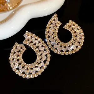 Vue détaillée de boucles d'oreilles gouttes géométriques ornées de zircons étincelants.