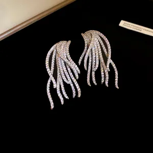 Stunning macro detail of 18k gold plated wing earrings with pavé set sparkling zircons