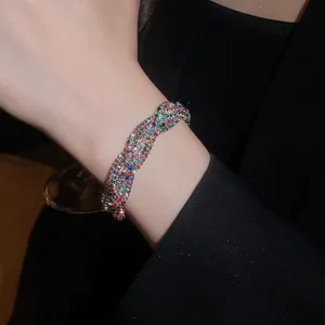 Detailansicht eines bunten, gedrehten Strass-Armbands im Vintage-Stil am Handgelenk.