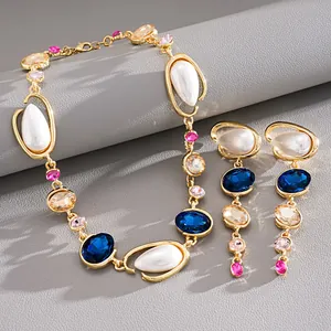 Detailed view of vintage gold-tone necklace and earrings with pearls and blue crystals