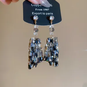 Primer plano de pendientes de lujo con cristales negros y grises brillantes