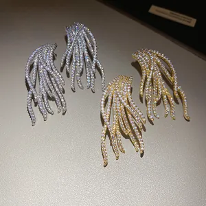 Detail view of 18k gold plated flowing tassel earrings with shimmering cubic zirconia