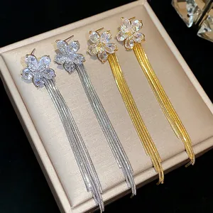 Detailed macro shot of zircon flower tassel earrings in gold and silver finish