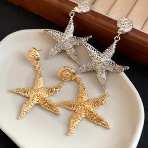 Vista dettagliata di eleganti orecchini a stella marina con finitura testurizzata oro e argento