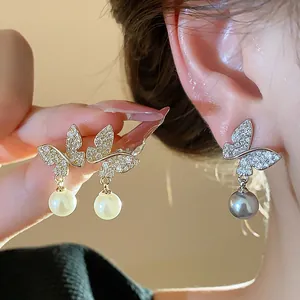Close-up of 18k gold plated butterfly pearl earrings with micro-pave zirconia details