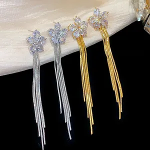 Detailed macro view of elegant zircon flower tassel earrings in gold and silver finish.