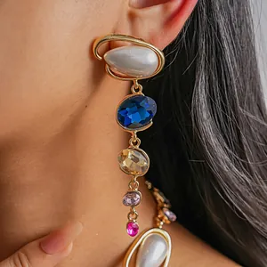 Close-up of elegant vintage teardrop pearl and multicolored crystal earrings on a model