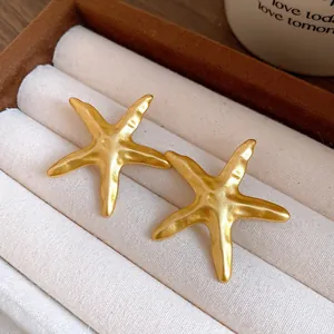 Close-up of elegant gold starfish stud earrings displayed in a luxury jewelry storage box