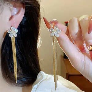 Detailed view of 18k gold plated flower tassel earrings with sparkling clear cubic zirconia.