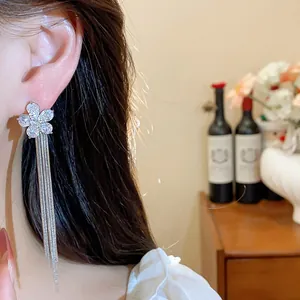 Detail shot of an elegant zirconia flower earring with long silver-colored tassels