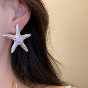Close-up detail of a vintage starfish earring with a shimmering silk-like silver finish