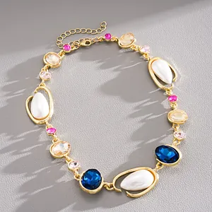 Detailed view of vintage necklace with blue crystals, pearls, and gold finish elements.