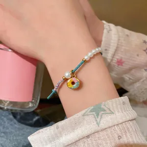 Handmade woven pearl bracelet with a colorful donut charm for a cute and elegant style