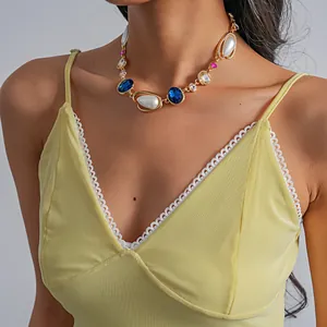 Detailed close-up of a retro geometric pearl necklace with blue and pink stones on a model
