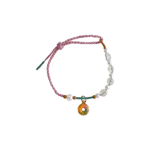 Handmade braided pearl bracelet with a colorful donut charm on white background