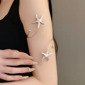 Detail view of silver metal wrinkled starfish open arm cuff bracelet worn on the upper arm