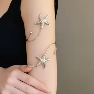 Close-up of elegant silver metal starfish arm cuff bracelet on a female upper arm.