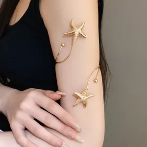 Detailed view of an elegant golden metal armlet featuring textured starfish motifs on arm