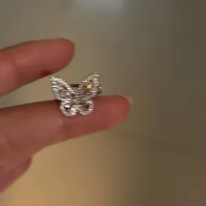 Detailed macro shot showing a sparkling silver butterfly ear cuff with cubic zirconia stones