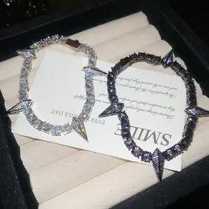Detail of punk style tennis bracelets with zircon spikes in silver and black purple tones.