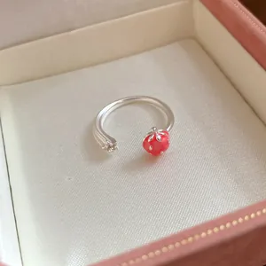 Detail view of a silver-colored strawberry and star open ring in a pink gift box.