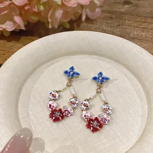 Elegant enamel flower drop earrings with white pearls and sparkling crystal accents.