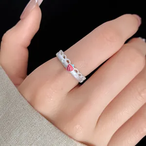 Close-up detail of a silver adjustable open ring featuring a strawberry charm and star lace patterns