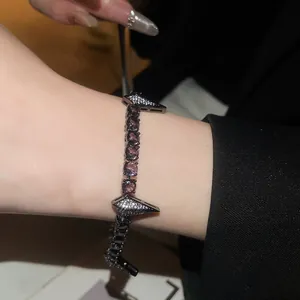 Detail view of hip-hop punk zircon bracelet with black metal and purple stones on wrist