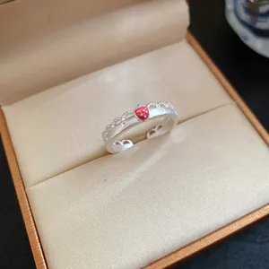 Close-up detail of a matte silver strawberry ring featuring star engravings in a box