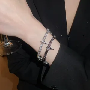 Close-up of sparkling zircon bracelets with punk-style geometric buckles on wrist