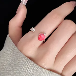 Detailed view of a minimalist silver open ring featuring a red strawberry and star.