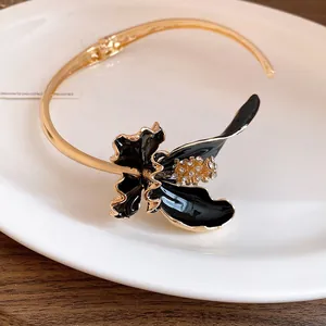 Gros plan d'un choker vintage français avec fleur en émail noir et strass