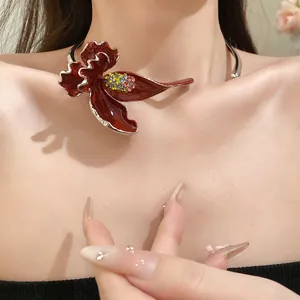 Détail d'un choker vintage français avec une grande fleur émaillée rouge et des strass.