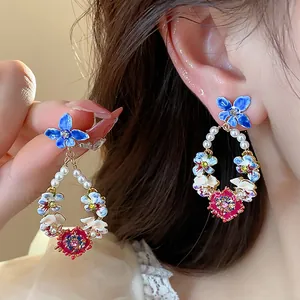 Close-up of elegant floral drop earrings featuring pearls and sparkling crystals